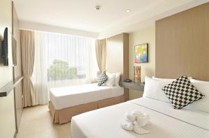 A bed or beds in a room at Belian Hotel
