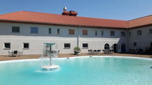 a swimming pool with a fountain in front of a building at Sturup Airport Hotel in Malmö Sturup