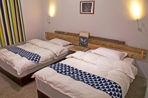 two twin beds in a room at Lijiang Adventure Inn in Lijiang