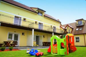 a yard with some toys on the grass in front of a house at Koral Apartamenty 1 min od morza, kuchnia, taras, place zabaw in Sarbinowo