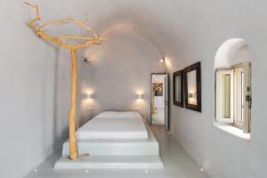 A bed or beds in a room at Ammos Oia Mansion