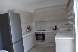 a small kitchen with a refrigerator and a stove at Marianna Hotel Apartments in Limassol