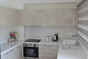 a white kitchen with a stove and a sink at Marianna Hotel Apartments in Limassol