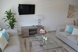 a living room with a couch and a table with flowers on it at Marianna Hotel Apartments in Limassol