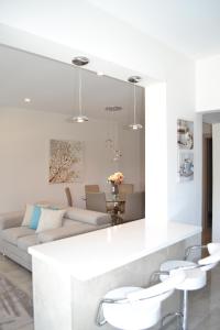 a white living room with a couch and chairs at Marianna Hotel Apartments in Limassol
