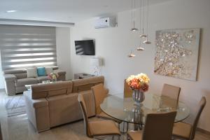a living room with a glass table and a couch at Marianna Hotel Apartments in Limassol