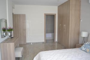 a bedroom with a bed and a desk with a dresser at Marianna Hotel Apartments in Limassol
