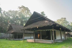 a house with a thatched roof and a grass at The Barefoot At Havelock in Havelock Island
