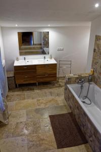 La grande salle de bains est pourvue d'une baignoire et d'un grand miroir. dans l'établissement Le Mas d'Isnard, à Arles