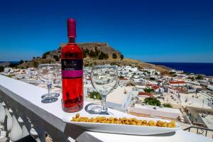 a bottle of wine sitting on a table with wine glasses at Domna Studios in Lindos