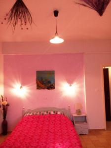 1 dormitorio con 1 cama con pared de color rosa en Skiathos city views studios-apartments en Skíathos