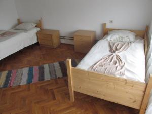 a bedroom with two twin beds and wooden floors at Country House Roman in Doboj