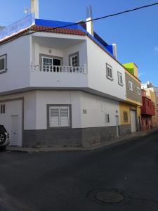 a white building with a balcony on a street at ka Sánchez vecindario in Vecindario