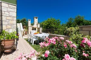 patio con tavolo e alcuni fiori rosa di Villa Flabellina ad Adelianos Kampos