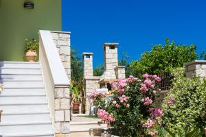 アデリアノス・カンポスにあるVilla Flabellinaの白い階段とピンクの花の家