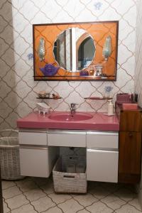 La salle de bains est pourvue d'un lavabo rose et d'un miroir. dans l'établissement Villa Tra' Monti, à Bassano del Grappa
