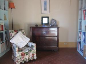 a room with a dresser and a chair with a mirror at S. Bartolomeo II° - "La Loggetta" in Montepulciano