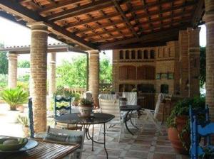 an outdoor patio with tables and chairs and a pavilion at Villa Chiarenza Maison d'Hotes in Giardini Naxos