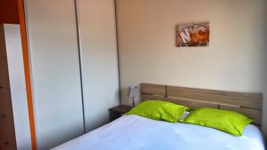 una camera da letto con un letto con cuscini verdi di Val Roya Terrasse a Nizza
