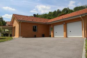 a house with two garage doors in a driveway at Gite Les Cimes in La Bresse