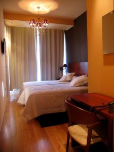 a bedroom with a large bed and a table at Hotel Casa de Caldelas in Castro Caldelas