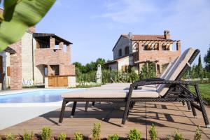 a black wicker chair sitting on a deck next to a pool at Villa Harmony in Paradise in Svetvinčenat