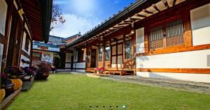 a courtyard of a building with a yard of grass at Gohyundang in Jeonju