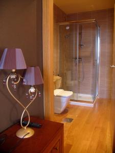 a bathroom with a shower and two lamps on a table at Hotel Casa de Caldelas in Castro Caldelas