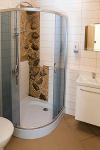 a shower with a glass door in a bathroom at Fortuna Hostel in Vilnius