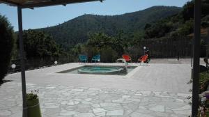 three chairs and a swimming pool with mountains in the background at Oroverde in Bergeggi