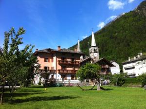 a large building with a clock tower in a field at Tre Alberi Liberi in Alagna Valsesia