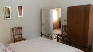 um quarto com uma cama, um armário e uma porta em Casa Dasy - Torre San Giovanni di Ugento ( Le ) em Torre San Giovanni Ugento