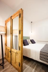 1 dormitorio con 1 cama y armario de madera en Jardines Boutique, en Madrid