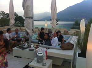 een groep mensen die op een tafel op een patio zitten bij Casa al Lido in Locarno