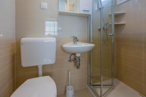 a bathroom with a toilet and a sink and a shower at Mobile Homes Pine Tree in Dobropoljana +30 photos