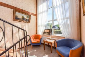 a living room with a blue chair and a window at Laukdvaris in Laukžemė