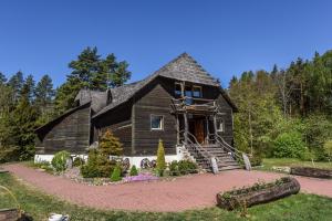 a wooden house with a porch and stairs to it at Laukdvaris in Laukžemė