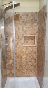 La salle de bains est pourvue d'une douche avec une porte en verre. dans l'établissement B&B VIA VENETO, à Crotone