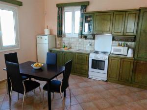 a kitchen with a table and chairs and a stove and refrigerator at Gythio Seaside Villa Dimitrios - Panoramic View in Gythio