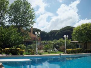 a swimming pool in front of a house with trees at Le Jardin d Eden in Sainte-Maxime