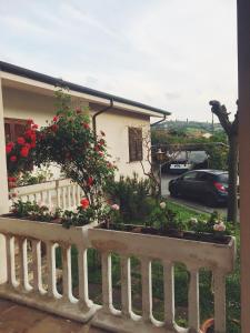 una casa con una valla blanca y flores rojas en Villa La Perla, en Corsanico-Bargecchia