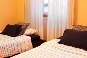 a room with two beds and a window at Casa Rosa in Leiria