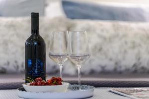 a bottle of wine and two wine glasses on a table at Jadranka studio apartments in Dubrovnik