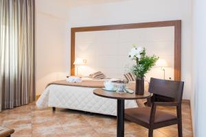 a bedroom with a bed with a table and a chair at Royal Hotel in Cosenza