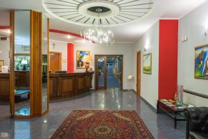 a lobby with red walls and a chandelier at Royal Hotel in Cosenza