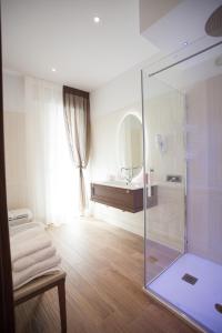 uma casa de banho com uma cabina de duche em vidro e um espelho. em Casa di Lucia em Chioggia