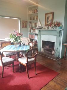 uma sala de estar com uma mesa e uma lareira em Twomey's Cottage em Queenscliff