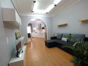 uma sala de estar com um sofá preto e uma cozinha em Eduardo Lucena 5, Alcázar em Córdoba