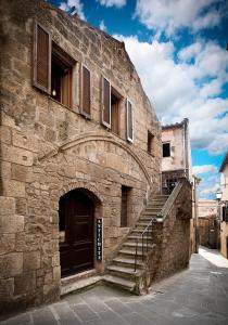 ピティリアーノにあるAntica Dimora San Roccoの階段と扉のある古い石造りの建物