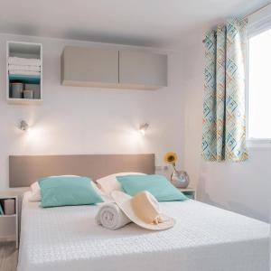 a bedroom with a bed with a hat on it at Giannella Camping in Orbetello